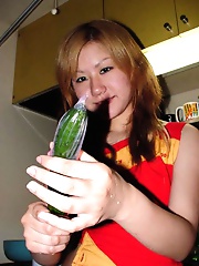 Asian teen puts a cucumber in her pussy